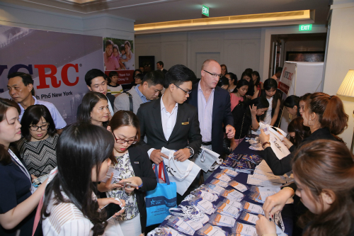 Attendees Registering for Ho Chi Minh EB-5 Delegation with NYCRC Poster in background.